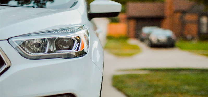 cropped view of a new car parked in a residential driveway