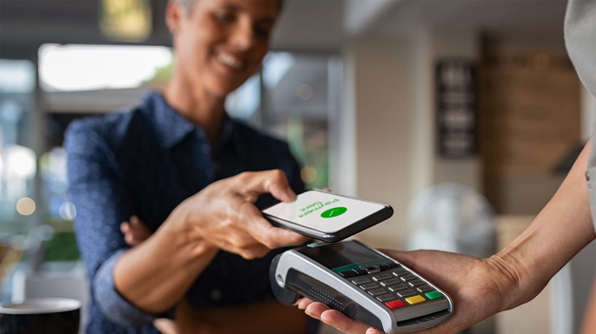 contactless payment terminal woman using her phone