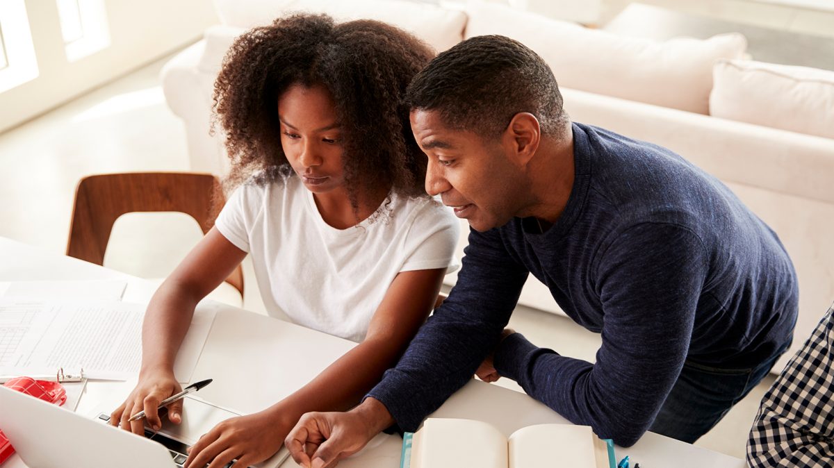 teenager and father budgeting at computer