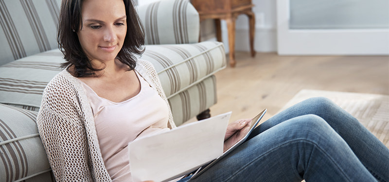 Woman reading while sitting on floor in home