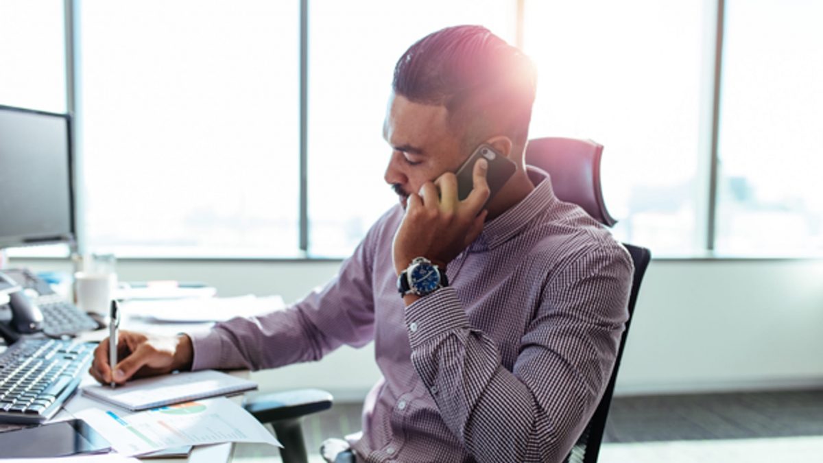 Man working on a computer and talking on the phone in an office