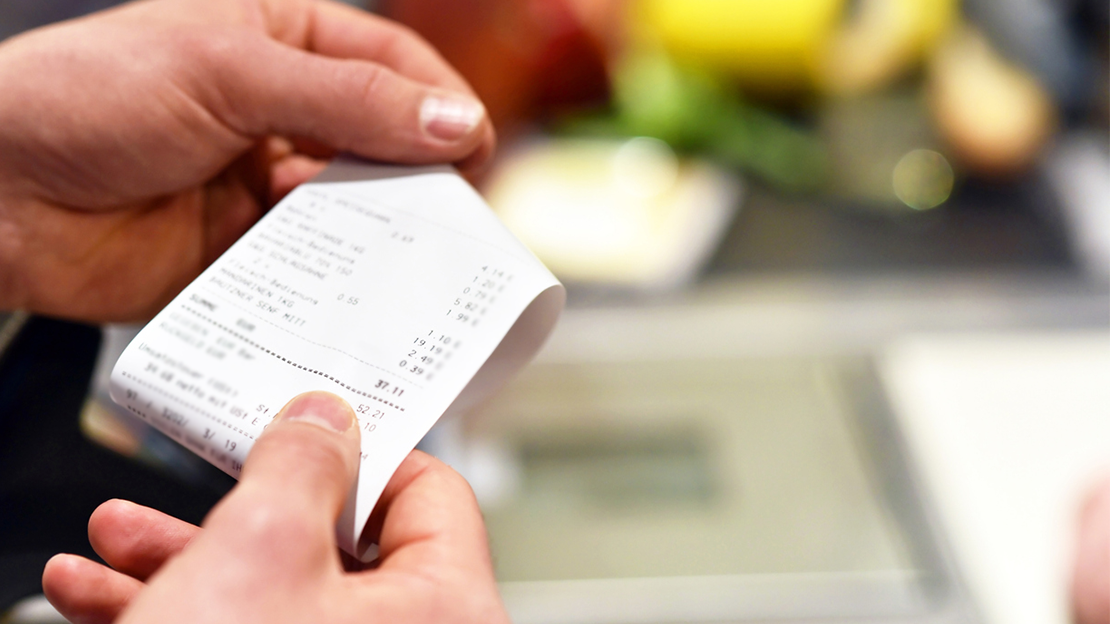 man holding grocery receipt bill