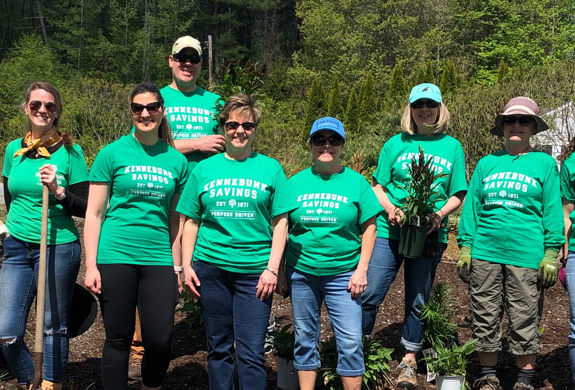 A group of smiling Kennebunk Savings volunteers pose for a photo at Mary's Walk.