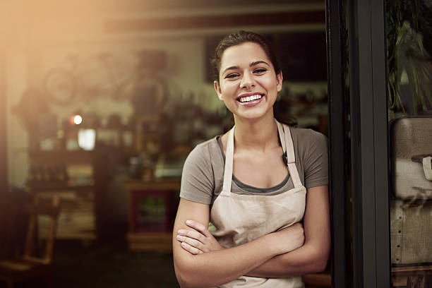 Portrait of a confident young woman standing in the doorway of a coffee shop