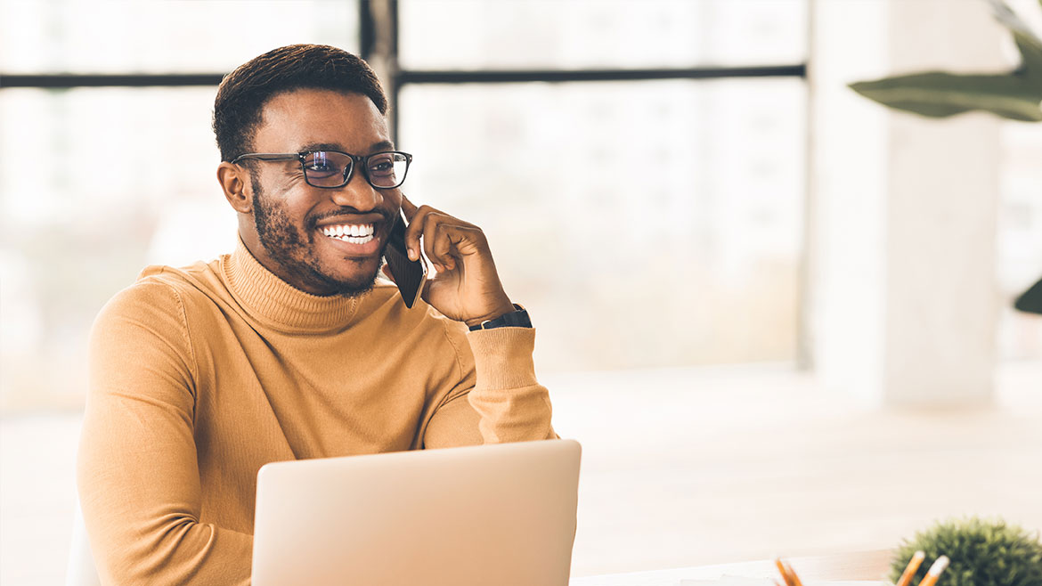 Young man speaking on the phone with a student loan counselor